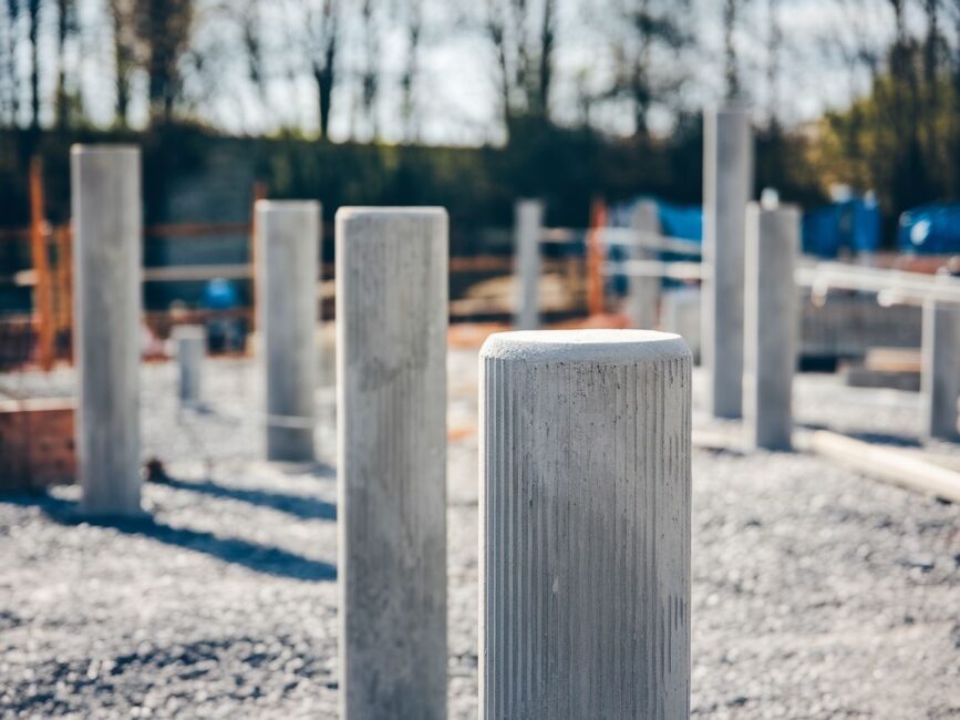 Świeżo wylany beton pod słupki na placu budowy